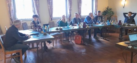 Landwirt:innen und Projektmitarbeitende sitzen an Tischen und diskutieren